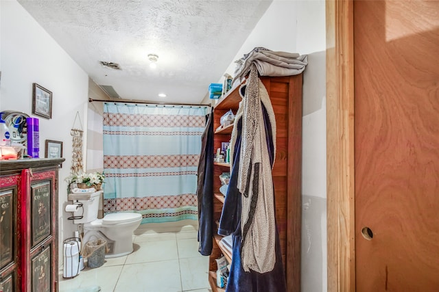 bathroom with toilet, a textured ceiling, curtained shower, and tile patterned floors