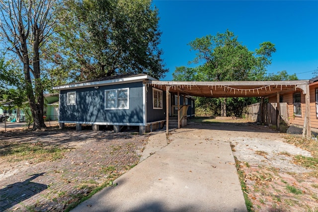 view of front facade featuring fence, a carport, and driveway