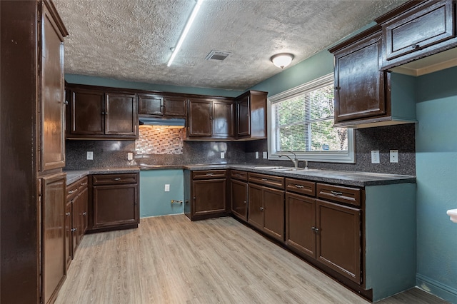 kitchen with light hardwood / wood-style floors, sink, and backsplash