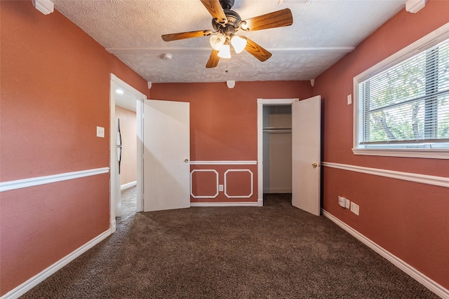 unfurnished bedroom with ceiling fan, a textured ceiling, carpet floors, and a closet