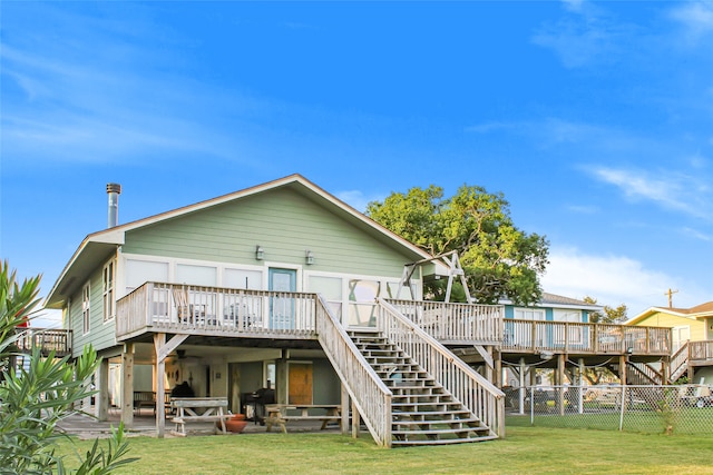 back of property featuring a wooden deck, a patio, and a yard