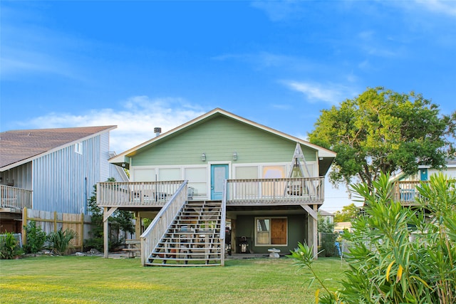 rear view of house featuring a wooden deck and a lawn