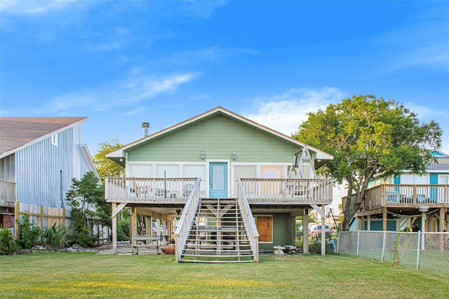 rear view of house with a yard and a wooden deck