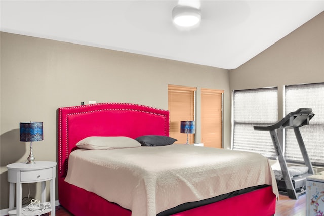 bedroom with wood-type flooring and vaulted ceiling