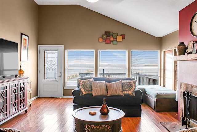 living room with high vaulted ceiling and light hardwood / wood-style floors