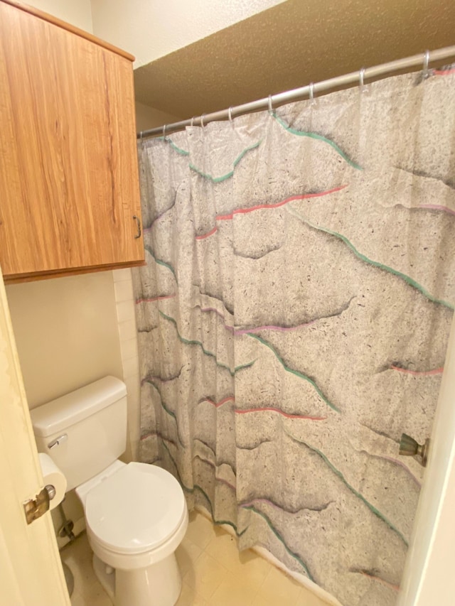 bathroom featuring curtained shower and toilet