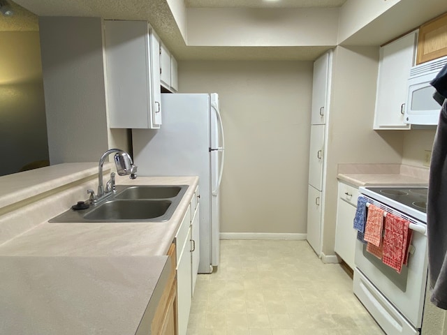 kitchen featuring white cabinetry, sink, and white appliances