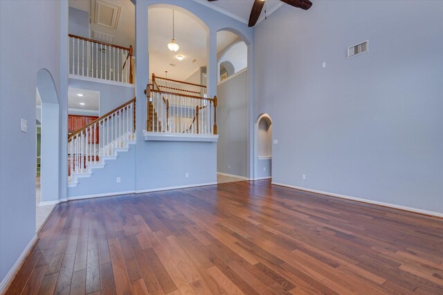 17519 Bighorn River Ln, Humble, TX 77346 - unfurnished living room with a towering ceiling, wood-type flooring, stairway, baseboards, and a ceiling fan