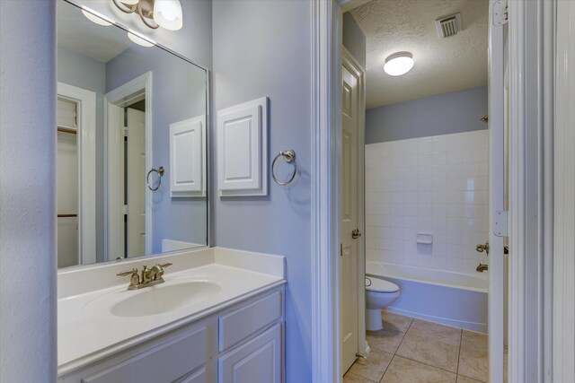 17519 Bighorn River Ln, Humble, TX 77346 - bathroom with toilet, vanity, tile patterned floors, a textured ceiling, and shower / bathtub combination