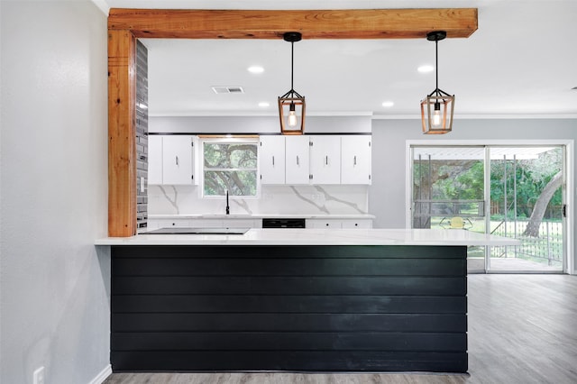 kitchen with a wealth of natural light, white cabinetry, and decorative light fixtures