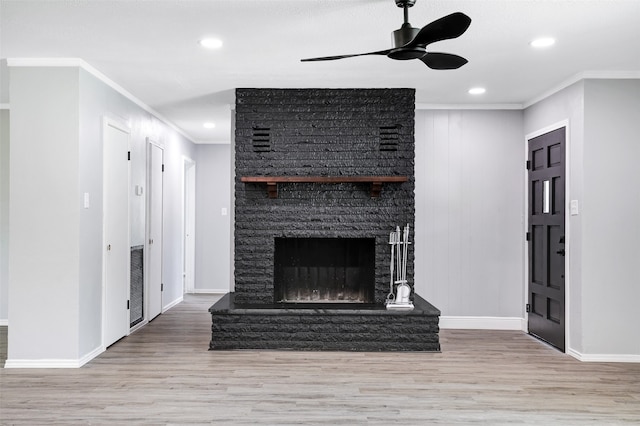 unfurnished living room with a stone fireplace, hardwood / wood-style flooring, ceiling fan, and crown molding