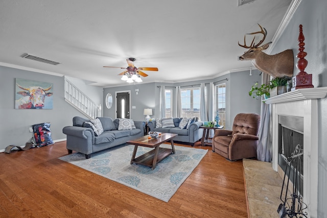 living room featuring crown molding, light hardwood / wood-style flooring, and ceiling fan