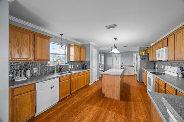 kitchen featuring white appliances, a kitchen island, dark hardwood / wood-style flooring, decorative light fixtures, and crown molding