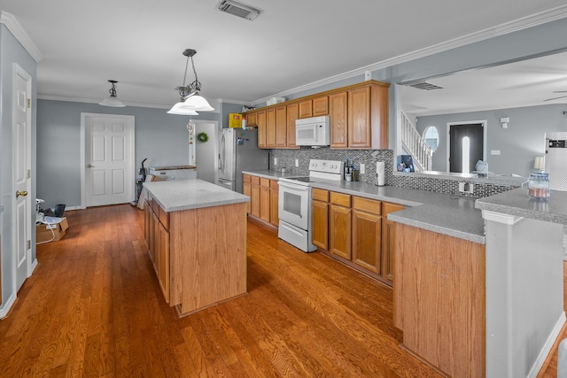 kitchen with white appliances, crown molding, tasteful backsplash, and hardwood / wood-style floors