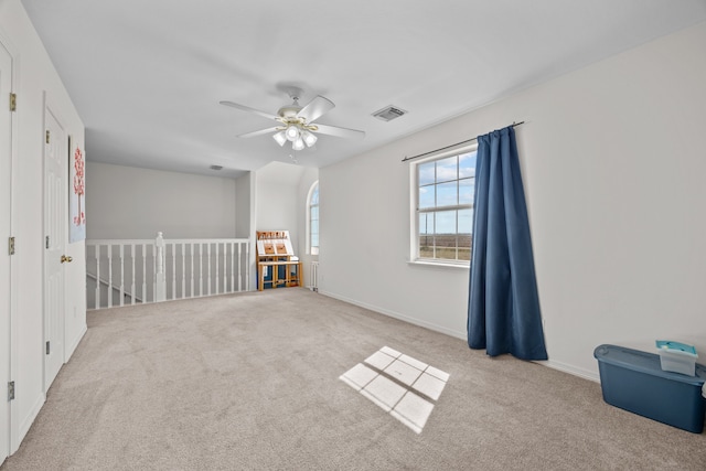 carpeted spare room featuring ceiling fan