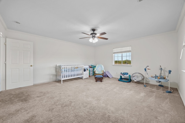 unfurnished bedroom featuring ceiling fan, crown molding, carpet floors, and a nursery area