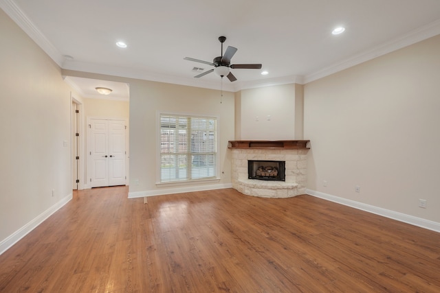 unfurnished living room with crown molding, a fireplace, hardwood / wood-style flooring, and ceiling fan