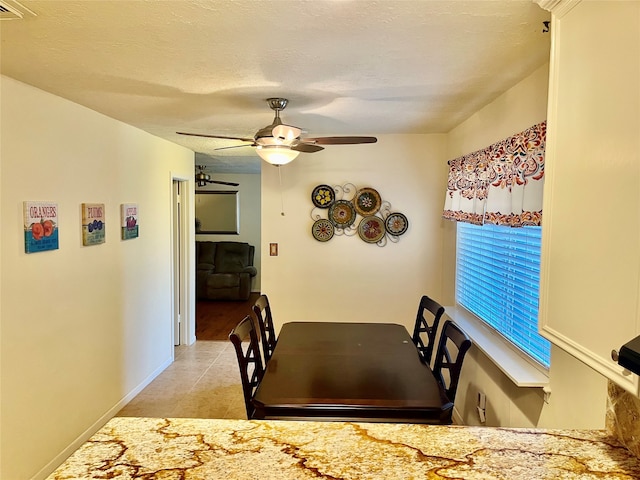 dining area featuring ceiling fan, a textured ceiling, and light tile patterned flooring