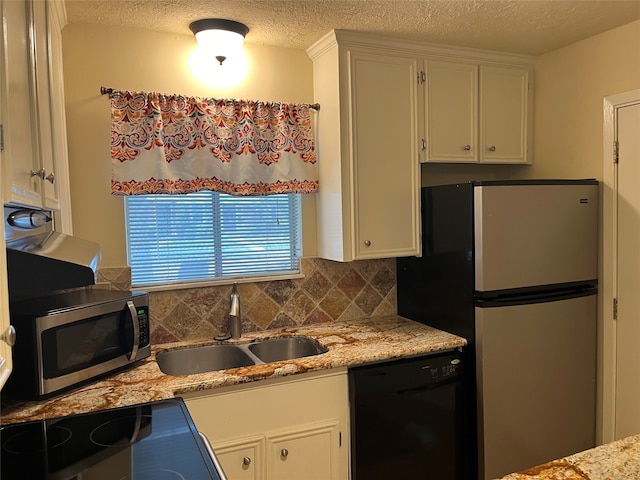 kitchen with appliances with stainless steel finishes, white cabinetry, and sink