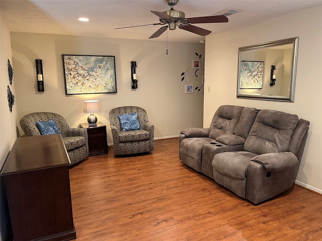 living room with a textured ceiling, hardwood / wood-style flooring, and ceiling fan