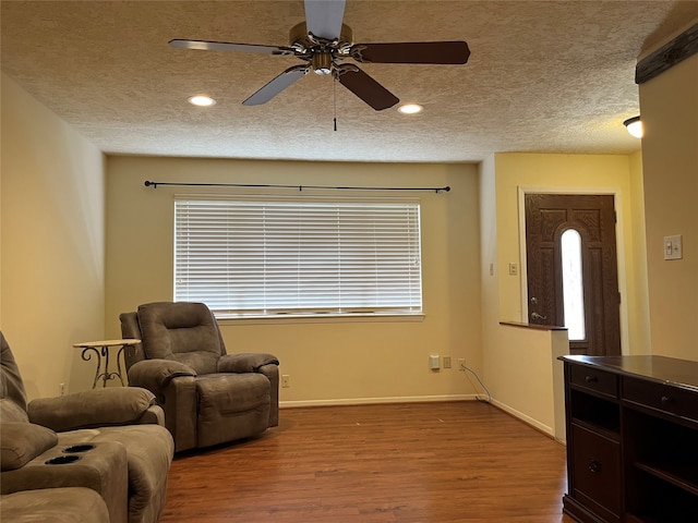 living room featuring a textured ceiling, light hardwood / wood-style floors, and ceiling fan