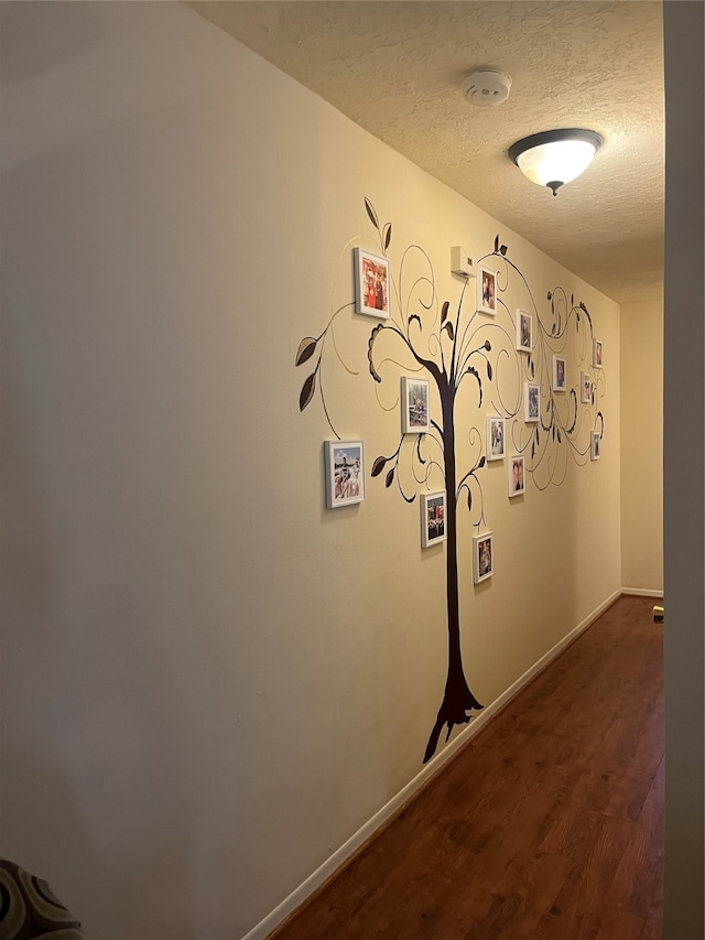 laundry area with dark wood-type flooring and a textured ceiling