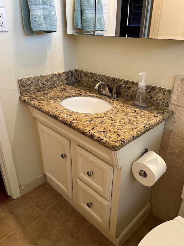 bathroom featuring vanity, toilet, and tile patterned flooring