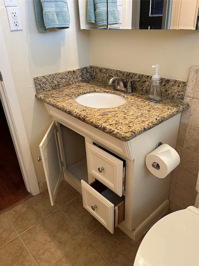 bathroom with vanity, toilet, and tile patterned flooring