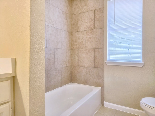 bathroom featuring toilet, vanity, tile patterned floors, and a washtub