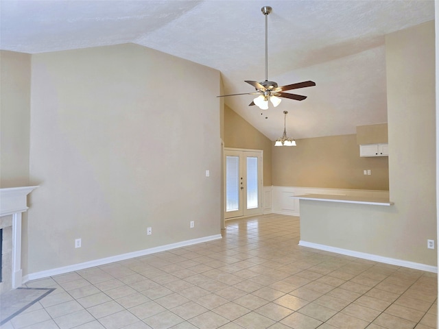 unfurnished living room with light tile patterned floors, vaulted ceiling, ceiling fan with notable chandelier, and a high end fireplace