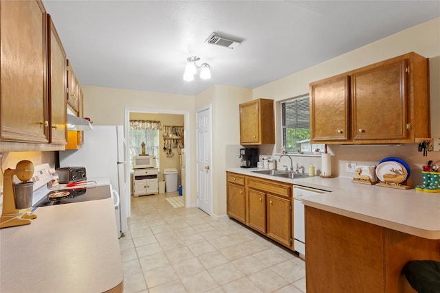 kitchen with white appliances, light tile patterned flooring, sink, and kitchen peninsula