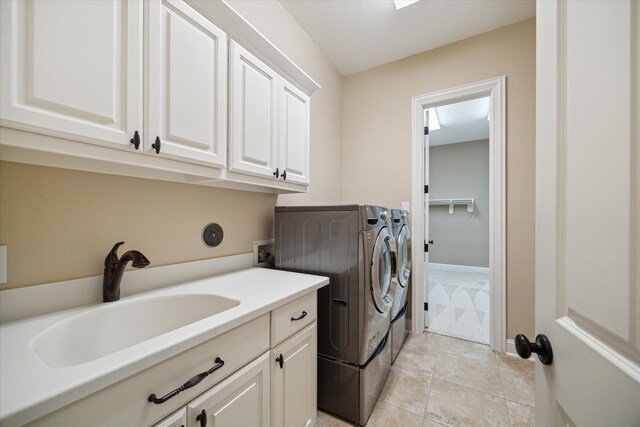 laundry room featuring cabinets, sink, light tile patterned flooring, and washer and dryer