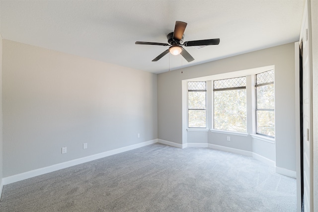 carpeted spare room with ceiling fan