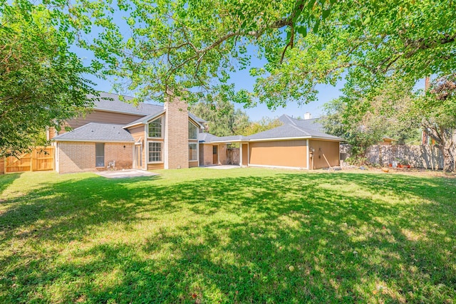 back of property featuring a yard and a patio