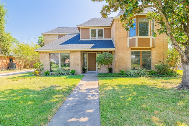 view of front of property with central AC and a front yard