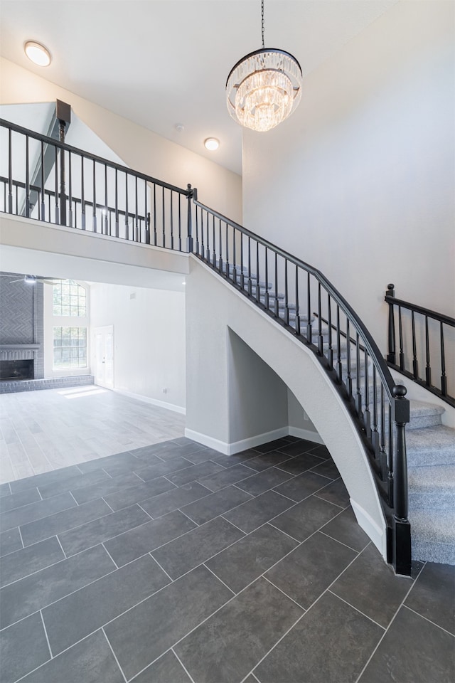 stairway featuring a notable chandelier, a towering ceiling, and tile patterned flooring