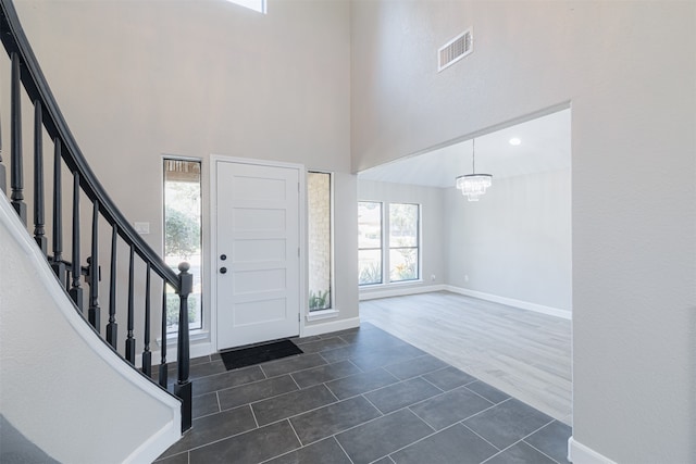 foyer with a high ceiling, a chandelier, and dark hardwood / wood-style flooring