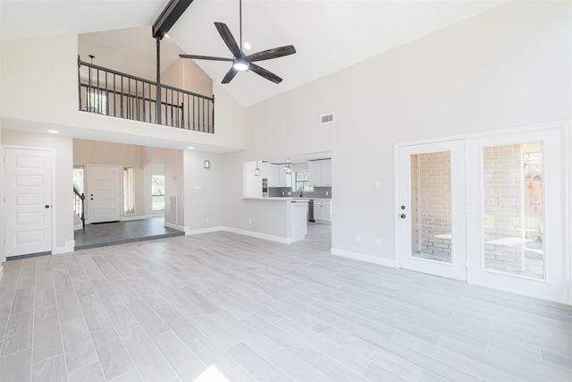 unfurnished living room featuring beam ceiling, light hardwood / wood-style floors, high vaulted ceiling, and ceiling fan