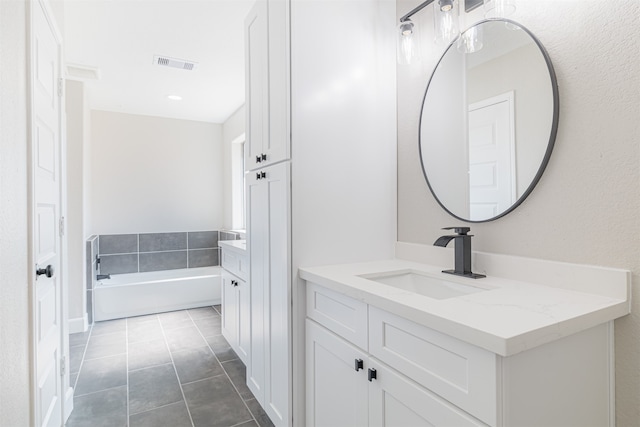 bathroom with vanity, a bath, and tile patterned floors