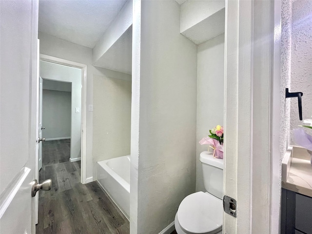 bathroom featuring a washtub, wood-type flooring, and toilet