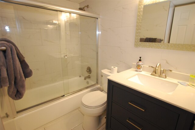 6102 Seawall Blvd Unit 161, Galveston, TX 77551 - full bathroom with tile walls, vanity, enclosed tub / shower combo, toilet, and tasteful backsplash