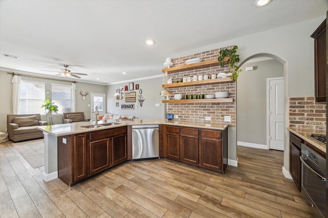 kitchen featuring kitchen peninsula, light wood-type flooring, stainless steel appliances, ceiling fan, and sink