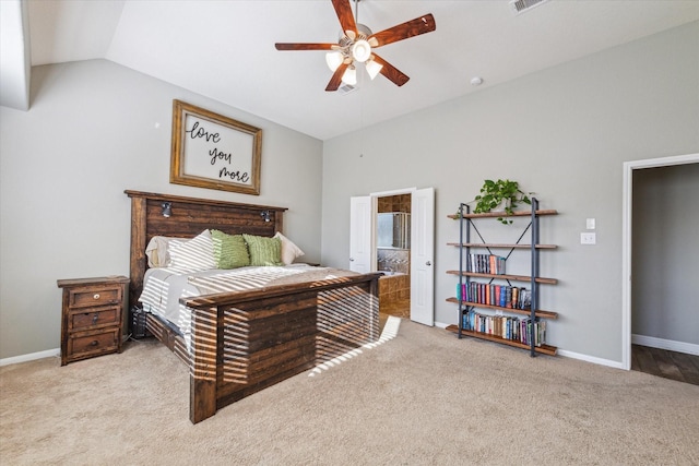 bedroom with ensuite bathroom, ceiling fan, light carpet, and vaulted ceiling