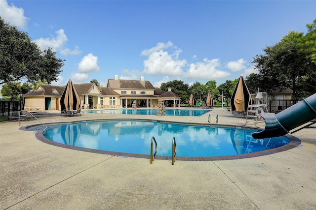 view of pool with a patio area and a water slide