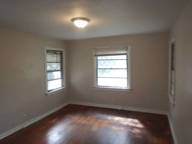 unfurnished room with dark hardwood / wood-style flooring