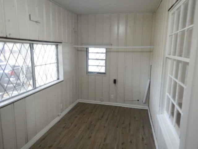 empty room featuring wood walls and dark hardwood / wood-style flooring