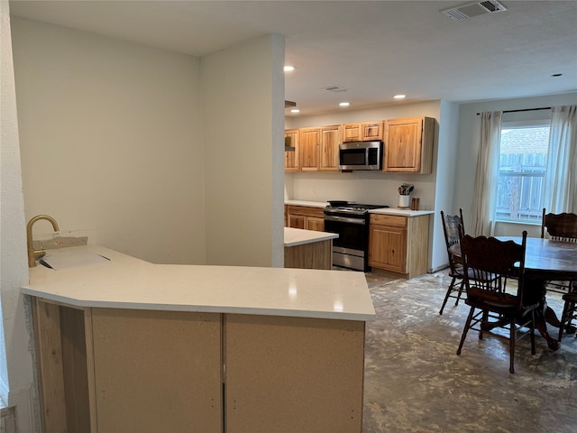 kitchen featuring stainless steel appliances, light brown cabinetry, sink, and kitchen peninsula