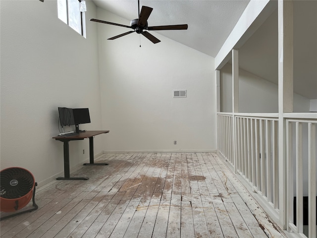 interior space featuring ceiling fan, a textured ceiling, lofted ceiling, and light wood-type flooring