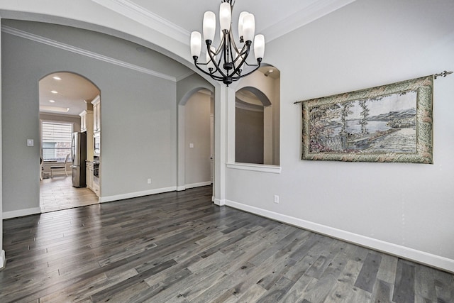 unfurnished dining area featuring crown molding, a chandelier, and hardwood / wood-style flooring