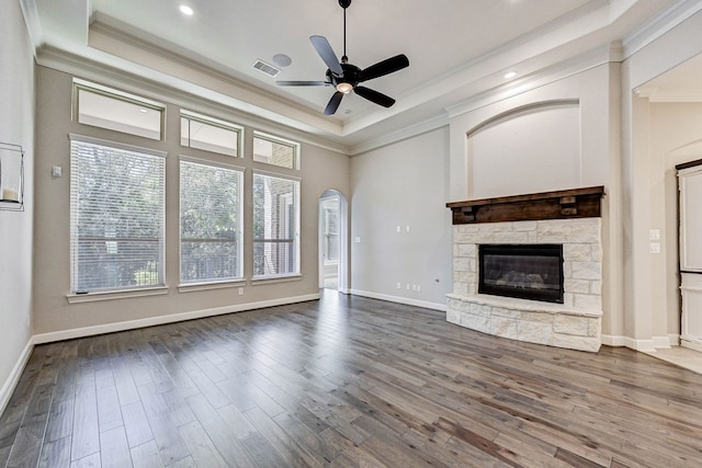 unfurnished living room featuring a fireplace, wood-type flooring, ceiling fan, and ornamental molding